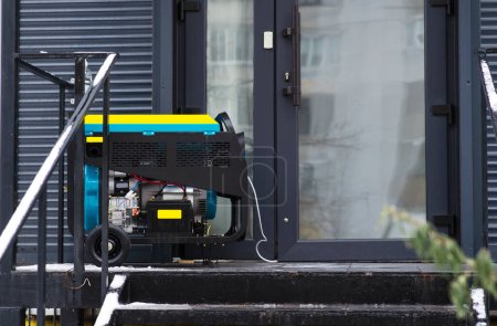 Portable electric generator running in the cold winter.Energy genocide. Power outage as a result of missile strikes by Russia on energy facilities of Ukraine. Small business use gasoline generators