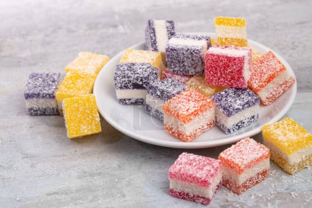 Photo for Cubes of multi-colored marmalade in powdered sugar on plate. The concept of baby sweets - Royalty Free Image