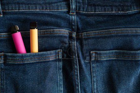 disposable electronic cigarettes in pants jeans pocket close-up