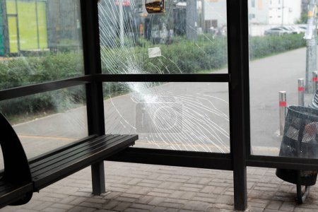 Photo for Broken glass at the bus stop. Public transport station vandalised by the glass windows. cracks of tempered glass - Royalty Free Image