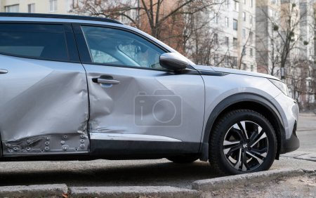 Téléchargez les photos : Dommages à une voiture moderne grise élégante de la carrosserie et des portes après un accident - en image libre de droit