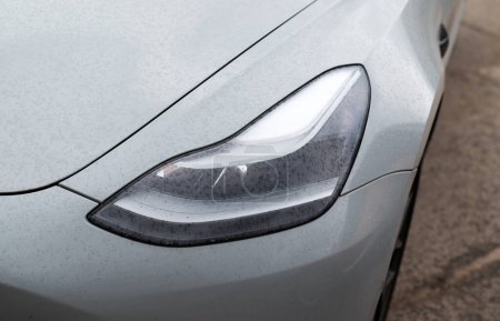 Foto de Kiev, Ucrania. 6 de abril de 2024. Faro. Faro led de un coche eléctrico gris moderno Tesla primer plano. - Imagen libre de derechos