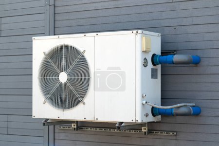 Condensing unit of air conditioning systems. Condensing unit installed on the gray wall