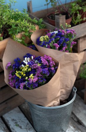 Strauß farbenfroher Blüten Limonium oder Statice (Meeres-Lavendel, Caspia oder Sumpfrosmarin) in Bastelpapier