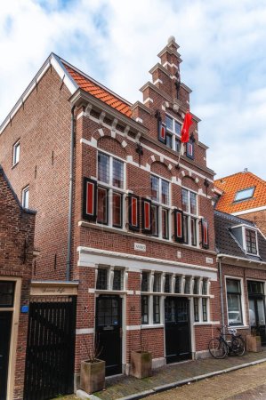 Téléchargez les photos : Vieille maison de ville de pavés avec ciel bleu clair. Ancienne maison traditionnelle en rangée aux Pays-Bas. - en image libre de droit