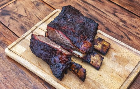 Photo for Barbecue burnt chuck beef ribs marinated and sliced with hot chili sauce as top view - Royalty Free Image