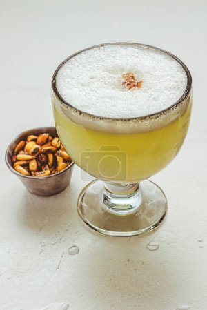 Gros plan sur le cocktail Pisco Sour, une boisson typique du Pérou et du Chili servie avec de la nourriture péruvienne traditionnelle à Lima