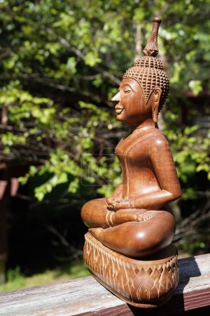 Foto de Una figura de madera de un buddha en un jardín - Imagen libre de derechos