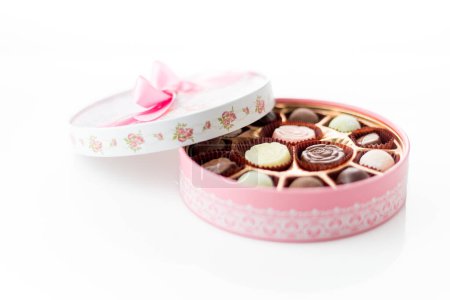 Téléchargez les photos : Boîte rose de chocolats avec ruban sur fond blanc - en image libre de droit
