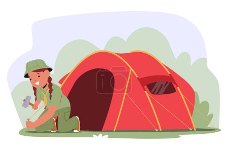 Jeune scoute portant un uniforme vert, occupé à installer la tente dans un espace extérieur herbeux. Elle manipule un marteau, démontre ses compétences en camping et sa préparation en milieu naturel, favorise le scoutisme