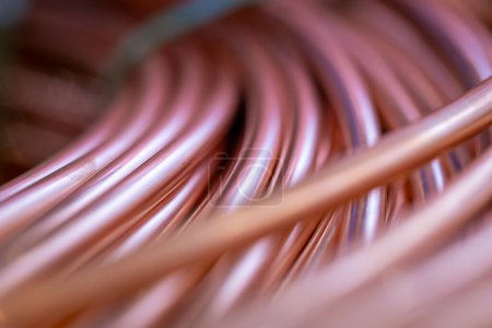 Close-up of new copper wire wound into a coil. Close-up of coils of copper wire. Copper wire randomly wound into a coil. A detailed shot of copper wires with selective focus.