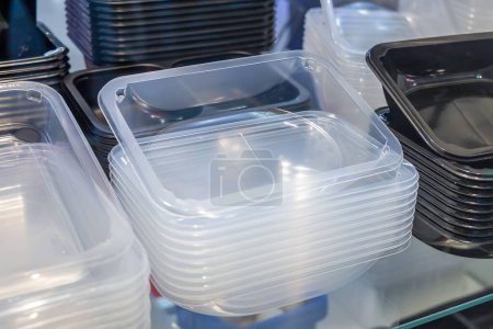 Montones de bandejas de plástico para envasar y transportar comida para llevar, o para envasar comidas preparadas en los supermercados. Embalaje plástico desechable.
