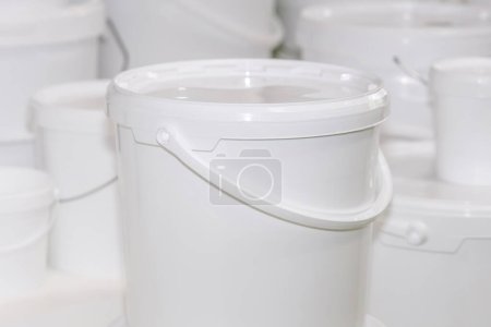 New white unmarked plastic bucket designed for storing and transporting food and liquids. Fair or shop.