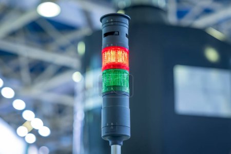 Traffic light at the machine. Red traffic light in a factory workshop. Industrial traffic light in a production workshop. Conveyor warning system.