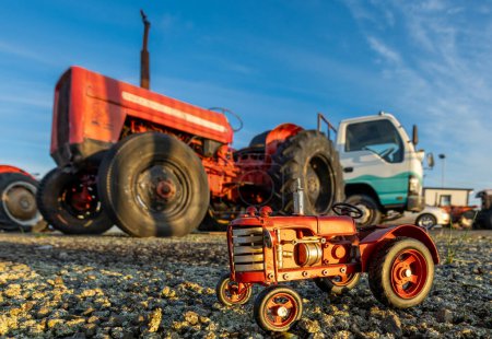 Foto de Foxton, Nueva Zelanda., 07 / 10 / 2023. Pequeño tractor rojo aparcado junto a un gran tractor rojo. - Imagen libre de derechos