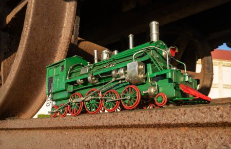 Foto de Locomotora de vapor verde con ruedas rojas en una vía férrea. - Imagen libre de derechos