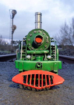 Foto de Locomotora de vapor verde con ruedas rojas en una vía férrea. - Imagen libre de derechos