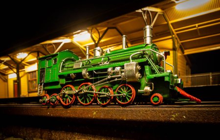 Foto de Locomotora de vapor verde con ruedas rojas en la estación de tren de Shannon por la noche. - Imagen libre de derechos