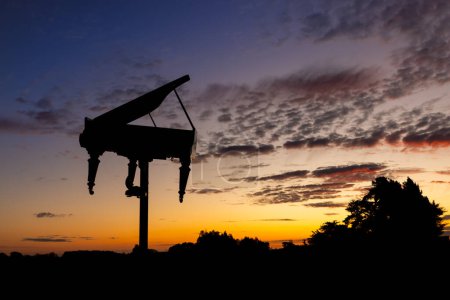 Foto de Gran piano en lo alto de un poste con un maravilloso cielo al atardecer. - Imagen libre de derechos