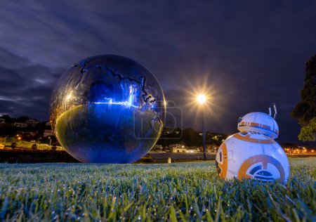 Foto de Whanganui, Nueva Zelanda, 26. 8.2023 Gran bola de metal con una gran grieta en ella. Y BB8 saqueándolo. - Imagen libre de derechos