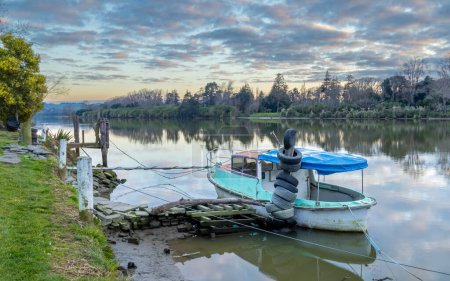 Foto de Un parque de barcos de río en la ciudad de Whanganui, con un cielo temprano en la mañana. - Imagen libre de derechos