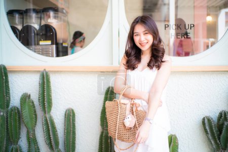 Pretty asian woman posting in coffee shop city travel relax in cafe