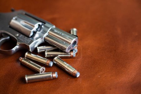 Téléchargez les photos : .357 magnum cacher défense petit pistolet avec veste balle pointe hallow sur cuir marron - en image libre de droit