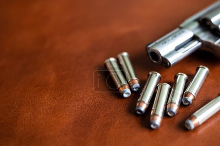 Téléchargez les photos : .357 magnum cacher défense petit pistolet avec veste balle pointe hallow sur cuir marron - en image libre de droit