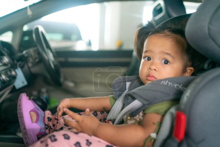Photo for Adorable toddler baby girl sitting in carseat on vacation trip safty transport - Royalty Free Image