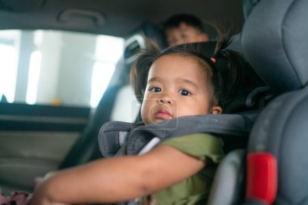 Photo for Adorable toddler baby girl sitting in carseat on vacation trip safty transport - Royalty Free Image