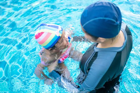Téléchargez les photos : Bébé fille bébé mignon profitant de nager avec maman dans la piscine activité extérieure - en image libre de droit