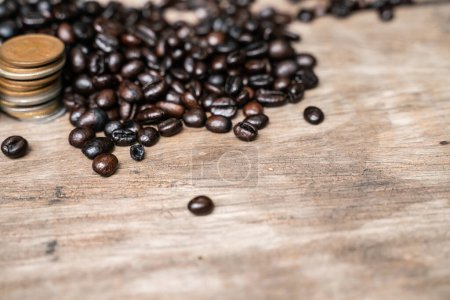 Kaffeebohne mit Münze auf Holztisch Kaffee-Business-Konzept