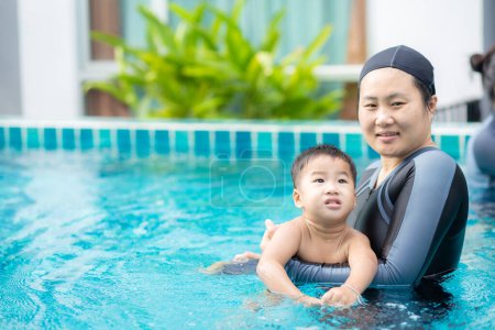 Téléchargez les photos : Bébé garçon tout-petit profitant de la natation avec maman dans la piscine, Loisirs sportifs - en image libre de droit