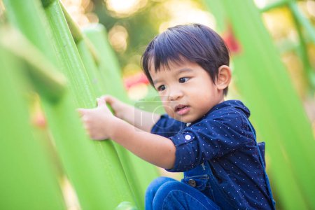 Photo for Adorable asian 2-3 years boy at playground in city park - Royalty Free Image