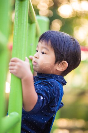 Foto de Adorable asiático 2-3 años chico en playground en ciudad parque - Imagen libre de derechos