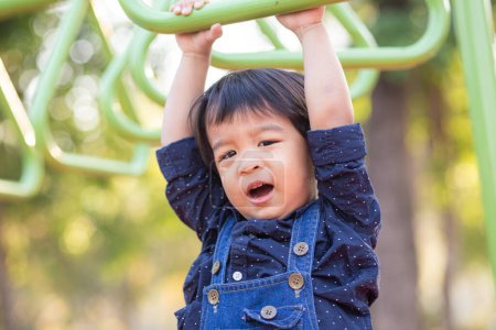 Téléchargez les photos : Adorable asiatique 2-3 ans garçon à aire de jeux dans la ville parc - en image libre de droit