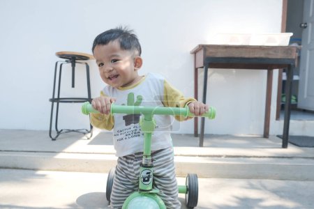 Foto de Feliz niño montando bicicleta de equilibrio en la ciudad - Imagen libre de derechos