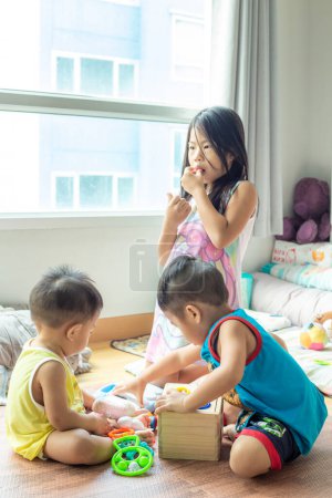 Foto de Feliz jardín de infantes niños disfrutando con juguete de madera juntos en acogedora casa hermano y hermana jugando juntos - Imagen libre de derechos