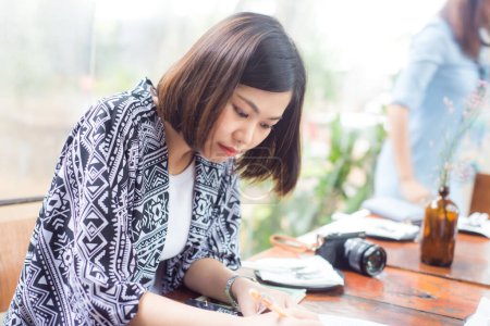 Téléchargez les photos : Asiatique belle femme lecture business plan dans café - en image libre de droit