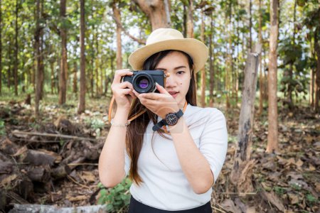 Photo for Hipster girl walking in forest with mirrorless camera, Nerd asian woman - Royalty Free Image