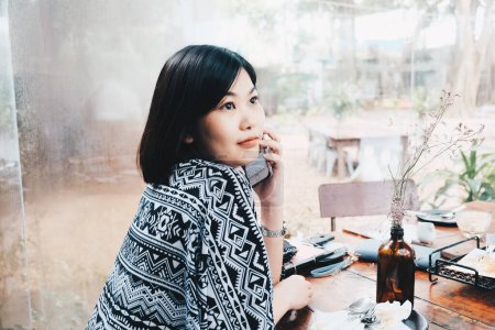 Foto de Mujer de negocios con teléfono inteligente sentado en la cafetería - Imagen libre de derechos