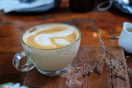 Foto de Arte latte caliente, taza de café en la mesa de madera - Imagen libre de derechos