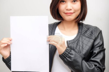 Téléchargez les photos : Heureuse femme d'affaires montrant papier blanc carte blanche sur fond blanc - en image libre de droit