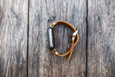 Téléchargez les photos : Bracelet en cuir montre intelligente sur table en bois - en image libre de droit