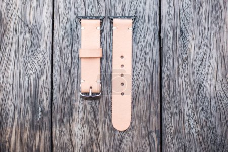 Téléchargez les photos : Pièces de bracelet de montre en cuir sur table en bois - en image libre de droit