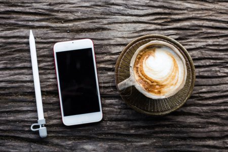 Foto de Smartphone con taza de café sobre fondo de madera - Imagen libre de derechos