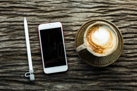 Photo for Smartphone with cup of coffee on wooden background - Royalty Free Image