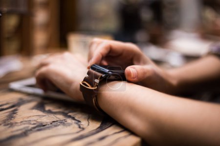 Téléchargez les photos : Femme utilisant la montre intelligente dans le café, gros plan sur la main - en image libre de droit