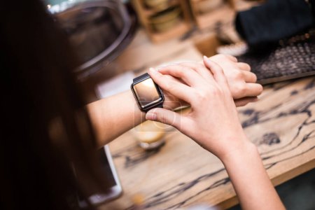 Foto de Mujer usando reloj inteligente en la cafetería, de cerca en la mano - Imagen libre de derechos
