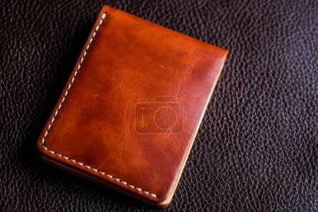 Photo for Brown genuine leather wallet on cowhide background, Craftsmanship object - Royalty Free Image